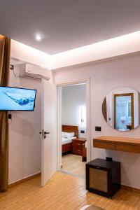 a hotel room with a television and a bedroom at Hotel ENAD in Ksamil
