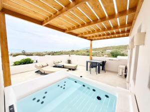 a hot tub on the patio of a house at Nohēme Luxury Suites in Vourvoúlos