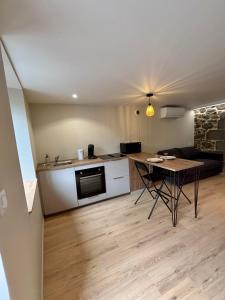 a kitchen and a living room with a table at Charmant studio en Auvergne in Orcines +5 photos