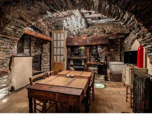 a dining room with a table and a stone wall at Soqquadro Art&Relax Alassio - Romantico Frantoio 1600 in Alassio