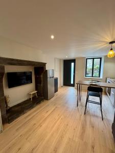 a large living room with a table and a refrigerator at Charmant studio en Auvergne in Orcines