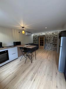 a kitchen with a table and a stone wall at Charmant studio en Auvergne in Orcines
