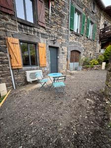 a table and two chairs in front of a building at Charmant studio en Auvergne in Orcines