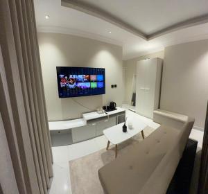 ein Wohnzimmer mit einem Fernseher an der Wand in der Unterkunft Sar studio in Khobar