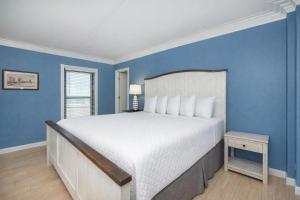 a bedroom with a large bed with blue walls at Island Winds East 501 in Gulf Shores +39 photos