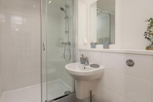 a white bathroom with a sink and a shower at Stylish City Centre Studio, Sleeps 2 in Sheffield +33 photos