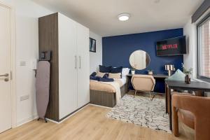 a bedroom with a bed and a desk with a mirror at Stylish City Centre Studio, Sleeps 2 in Sheffield