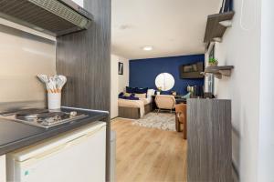a kitchen with a stove and a living room at Stylish City Centre Studio, Sleeps 2 in Sheffield
