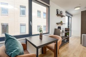 a living room with a table and chairs and windows at Stylish City Centre Studio, Sleeps 2 in Sheffield