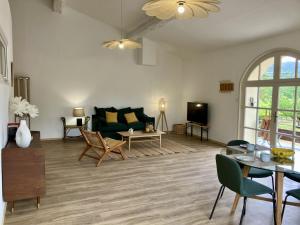 a living room with a couch and a table at Balcon sur les vignes - Loft de charme 2 pers in Cournanel