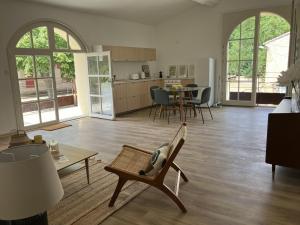 a living room with a chair and a table at Balcon sur les vignes - Loft de charme 2 pers in Cournanel