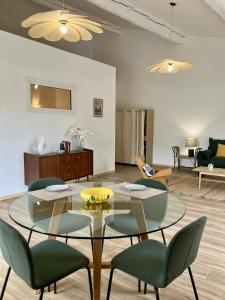 a living room with a glass table and chairs at Balcon sur les vignes - Loft de charme 2 pers in Cournanel