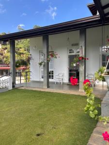 a patio with a lawn in front of a house at Villa Aureia in Bandarawela