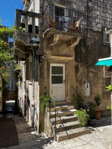 a stone building with a white door and stairs at White House Apartments in Korčula