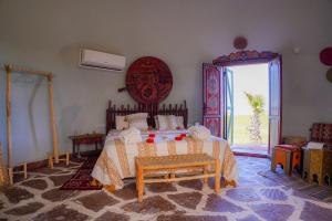 a bedroom with a bed and a large window at Agafay Valley in Marrakesh