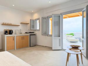 a kitchen with an open door leading to a patio at Nohēme Luxury Suites in Vourvoúlos