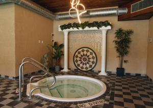 a bathroom with a tub in a room with a checkered floor at EasyStay Inn & Suites Fernie in Fernie +32 photos