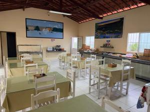 a restaurant with tables and chairs in a room at Pousada Sol Nascente in Piranhas
