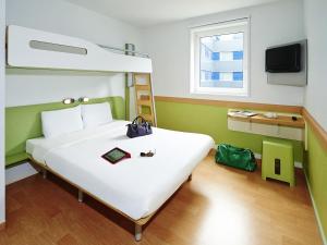 a bedroom with a large white bed and a bunk bed at Ibis Budget Hyères in Hyères +49 photos
