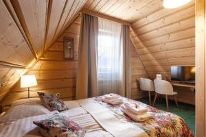 a bedroom with a bed in a wooden house at Góralski Gościniec & SPA in Poronin