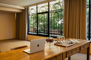a laptop sitting on a wooden table with a window at QC Room Milano Porta Romana in Milan