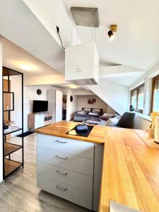 a kitchen with white cabinets and a living room at Ferienwohnung Artemis in Eggingen