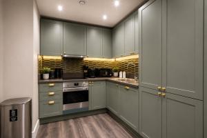 a kitchen with green cabinets and a stove at The Orpington View in Orpington