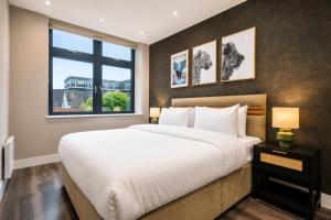 a bedroom with a large bed and a window at The Orpington View in Orpington