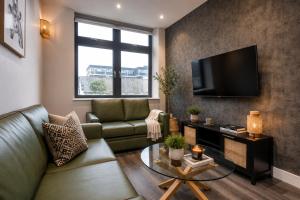 a living room with a couch and a tv at The Orpington View in Orpington