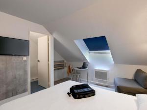 a suitcase sitting on a bed in a room at ibis budget Vannes in Vannes