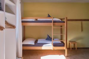 two bunk beds in a room with blue sheets and pillows at Hotel Bellavista Ftan in Ftan +7 photos