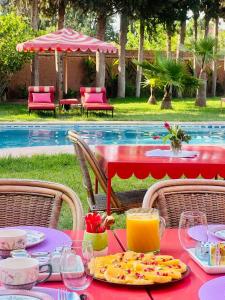 a red table with food on it next to a pool at Villa Samadhi - Luxury & Serenity in Marrakesh