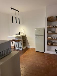 a kitchen with a white refrigerator and a table at Casa Nina in Valbravenna