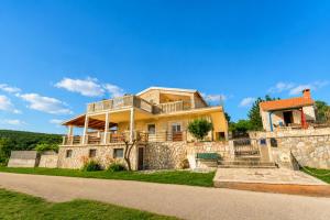 a large yellow house with a stone wall at Villa Bella in Kruševo