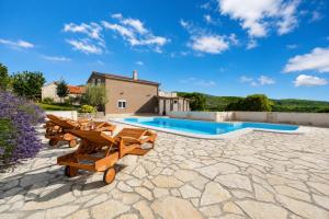 a patio with wooden chairs and a swimming pool at Villa Bella in Kruševo