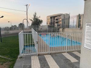 a gate in front of a swimming pool at Acogedor apartamento in Quilpué