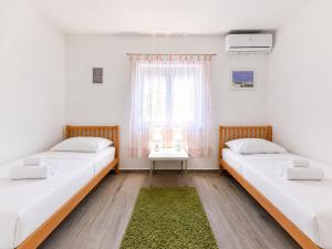 two beds in a room with a window at Villa Bella in Kruševo +20 photos