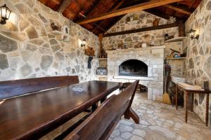 a stone room with a table and a fireplace at Villa Bella in Kruševo