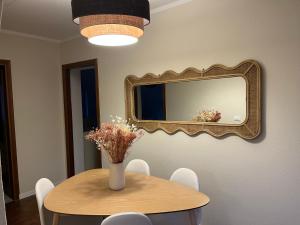 a table with a vase of flowers and a mirror at Casa Nina in Valbravenna +1 photo