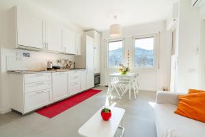 a white kitchen with a white couch and a table at Appartamento x 4 con wi-fi, park free, a 10 minuti dal centro di Garda in Garda +7 photos
