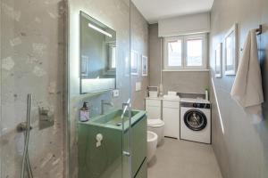 a bathroom with a sink and a washing machine at Appartamento x 4 con wi-fi, park free, a 10 minuti dal centro di Garda in Garda