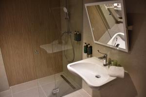 a bathroom with a sink and a shower with a mirror at Hotel Dom in Studenci +29 photos