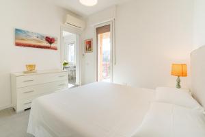 a white bedroom with a white bed and a window at Appartamento x 4 con wi-fi, park free, a 10 minuti dal centro di Garda in Garda