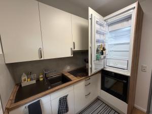 a kitchen with a sink and an empty refrigerator at Ferienwohnung Janni in Bad Zwischenahn