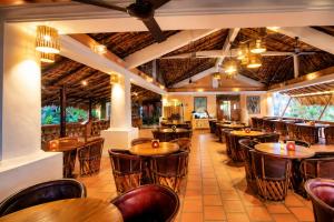 a restaurant with wooden tables and chairs at Hotel Santa Fe in Puerto Escondido