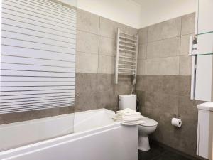 a bathroom with a white tub and a toilet at Apartment v podzámčí in Františkovy Lázně