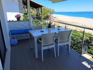 a table and chairs on a balcony with the beach at Aegean Infinite View-Beachfront Suite Pelion in Chorefto