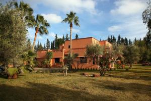 a house with palm trees in front of it at Villa Samadhi - Luxury & Serenity in Marrakesh