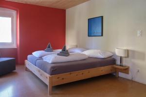 a bed in a room with a red wall at Hotel Bellavista Ftan in Ftan