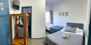 a room with two beds and a ladder in it at Pousada Silvestre in Tramandaí